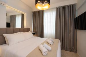 a bedroom with a large white bed with towels on it at Dema Luxury Suites - Perikleous E6 in Athens