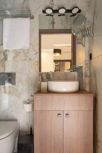een badkamer met een wastafel, een spiegel en een toilet bij Dema's Luxury Suites(E6) in Athene
