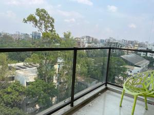 een balkon met een stoel en uitzicht op de stad bij Hibiscus Apartments in Dhaka