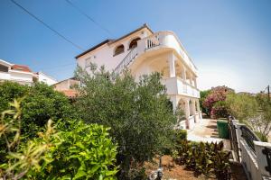 a white building with a balcony on top of it at Apartments Marina in Petrcane