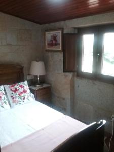 una camera con letto, lampada e finestre di Casa Do Conde a Caldas de Reis