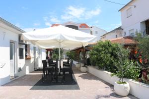a table and chairs under an umbrella on a patio at Apartments Marina in Petrcane
