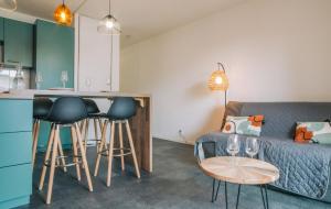 sala de estar con sofá y cocina con taburetes en T2 moderne avec terrasse à 900m des plages, en Guéthary