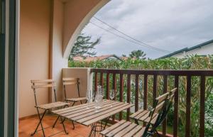 y balcón con mesa y sillas de madera. en T2 moderne avec terrasse à 900m des plages, en Guéthary