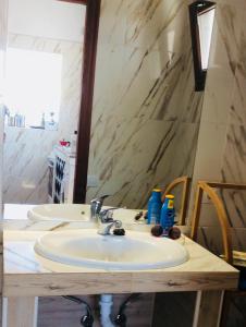 uma casa de banho com 2 lavatórios e um espelho em Lovely Cottage em La Oliva