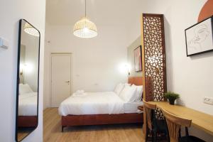 - une chambre avec un lit et un miroir dans l'établissement Bruno 55 By Peraia, à Tel Aviv