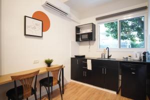 une cuisine avec des armoires noires et une table en bois dans l'établissement Bruno 55 By Peraia, à Tel Aviv