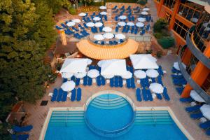 - une vue sur la piscine bordée de chaises et de parasols bleus dans l'établissement Atlas Hotel - Free Outdoor Pool and Heated Indoor Pool, aux Sables d'or