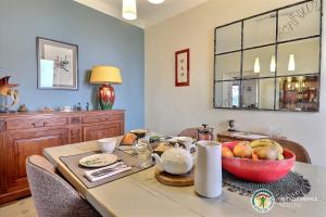 a dining room table with a bowl of fruit on it at Les Volets Rouges in Saint-Sauveur-de-Cruzières