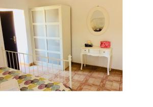 a bedroom with a bed and a table with a mirror at Lovely Cottage in La Oliva