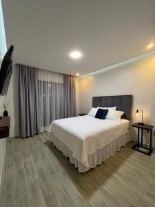una camera da letto con un letto grande e un tavolo di Apartamentos Orquidea Dorada apt 101 & 104 a Comayagua