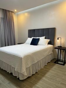 una camera da letto con un letto grande con testiera grigia di Apartamentos Orquidea Dorada apt 101 & 104 a Comayagua