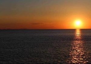 a sunset over the ocean with the sun in the sky at Apartments Marina in Petrcane