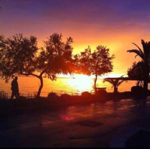 a person walking in front of a sunset at Apartments Marina in Petrcane