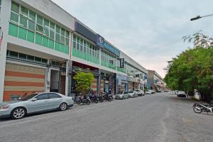 a city street with cars parked in front of buildings at 4S Hotel in Muar