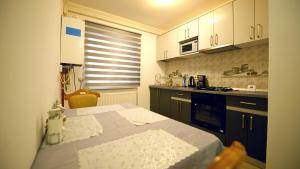 a small kitchen with a table and a stove at Apartament Trandafirilor in Haţeg