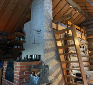 a kitchen with a brick oven with a clock on the wall at Log Cabin - Lord of Sormuset in Inari