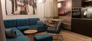 ein Wohnzimmer mit einem blauen Sofa und einem Tisch in der Unterkunft DVOSJED apartmani Jahorina in Jahorina