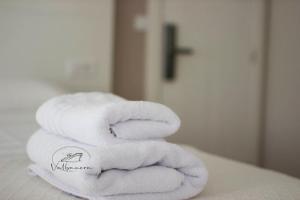 una pila de toallas sentadas encima de una cama en Valbanera, en Colombres