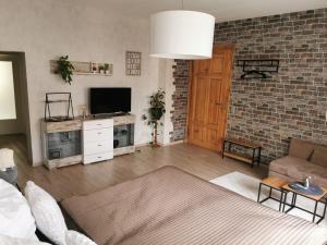 a living room with a television and a brick wall at Ferienwohnung Luise mit separater Küche in Naumburg