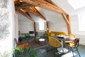 ein Wohnzimmer mit einem Tisch und Stühlen in der Unterkunft Le Grand Amerval in Nancy