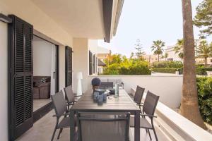 a wooden table and chairs on a balcony with a table at Es descans in Can Picafort