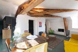 a living room with a dining room table and chairs at Le Grand Amerval - Joli appartement climatisé in Nancy