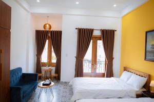 Trú Homestay Huế في Thôn Dương Xuân Hạ: غرفة نوم بسريرين واريكة زرقاء