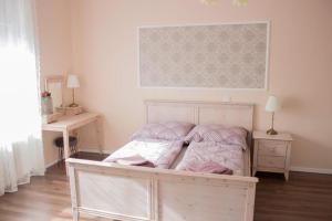 um quarto com uma cama com lençóis cor-de-rosa e brancos em Broadway Apartments B3 em Debrecen