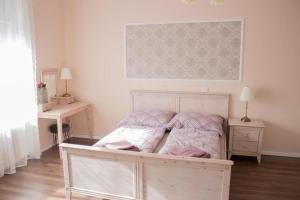 a bedroom with a bed with pink and white sheets at Broadway Apartments B3 in Debrecen