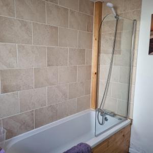 a bathroom with a shower and a tub at Dare Valley Cottage Ex miners cottage Near Zip World Pen y fan Waterfalls in Aberdare