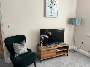 a living room with a chair and a television at The Snicket Apartment in Basingstoke