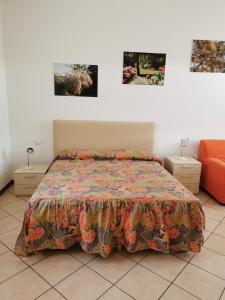 um quarto com uma cama e duas fotografias na parede em B&B La Tamerice em Valeggio sul Mincio