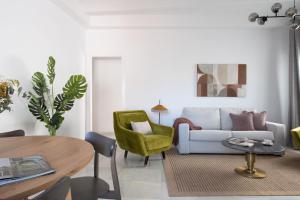 - un salon avec un canapé et une table dans l'établissement Suites Maestranza - Puerta del Arenal by Magno Apartments, à Séville