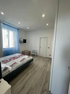 een slaapkamer met een bed en een houten vloer bij Appartamento Il cielo in una stanza- Vista Mare! in Nettuno