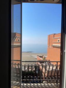 een raam met uitzicht op de oceaan vanuit een gebouw bij Appartamento Il cielo in una stanza- Vista Mare! in Nettuno