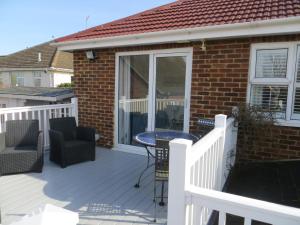 a deck with a table and chairs on a house at Hunnydorm in Hunstanton