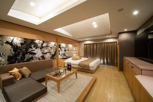a room with a bed and a couch and a table at ホテル リッド 男塾ホテルグループ in Hikone