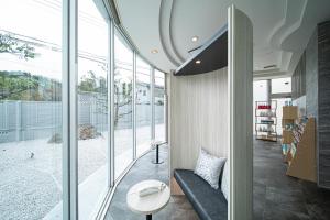 um quarto com janelas de vidro, um sofá e uma mesa em ホテル リッド 男塾ホテルグループ em Hikone