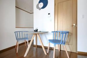 a table and two blue chairs in a room at Pirane House 201 東京スカイツリー浅草 押上駅が徒歩圏内 無料wifi in Tokyo