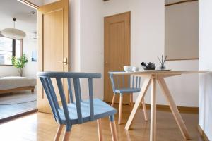 a dining room with a table and two blue chairs at Pirane House 201 東京スカイツリー浅草 押上駅が徒歩圏内 無料wifi in Tokyo