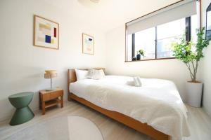 a white bedroom with a bed and a window at Pirane House 201 東京スカイツリー浅草 押上駅が徒歩圏内 無料wifi in Tokyo