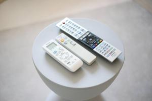 three remote controls sitting on top of a table at Pirane House 201 東京スカイツリー浅草 押上駅が徒歩圏内 無料wifi in Tokyo