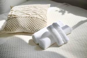 a pile of towels on a bed with a pillow at Pirane House 201 東京スカイツリー浅草 押上駅が徒歩圏内 無料wifi in Tokyo