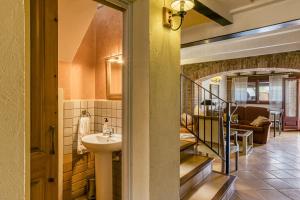 a bathroom with a sink and a staircase with a living room at Ca La Maria in Orriols