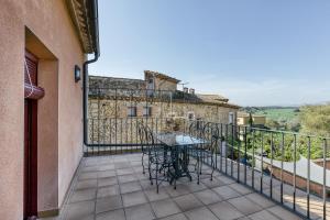 un patio con tavolo e sedie sul balcone. di Ca La Maria a Orriols