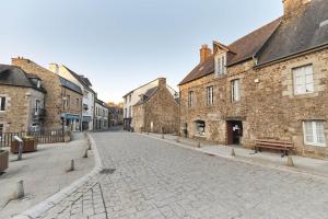 una calle adoquinada en un casco antiguo con edificios de piedra en La Bonne Etoile, en Châtelaudren