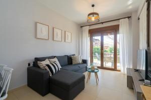 a living room with a couch and a tv at M-Home, My Paradise Home in Neos Marmaras