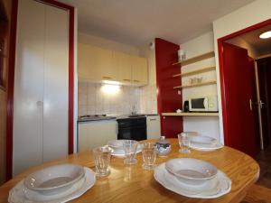 eine Küche mit einem Holztisch mit Tellern und Gläsern in der Unterkunft Appartement Aussois, 2 pièces, 4 personnes - FR-1-508-289 in Aussois