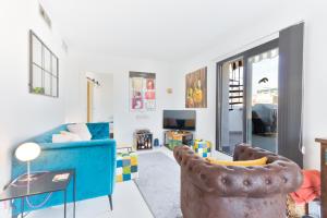 een woonkamer met een blauwe bank en stoelen bij Old City Penthouse with fantastic views & parking in Benidorm